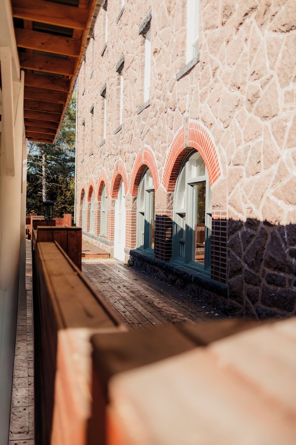 A stone building with arched windows and a wooden bench.