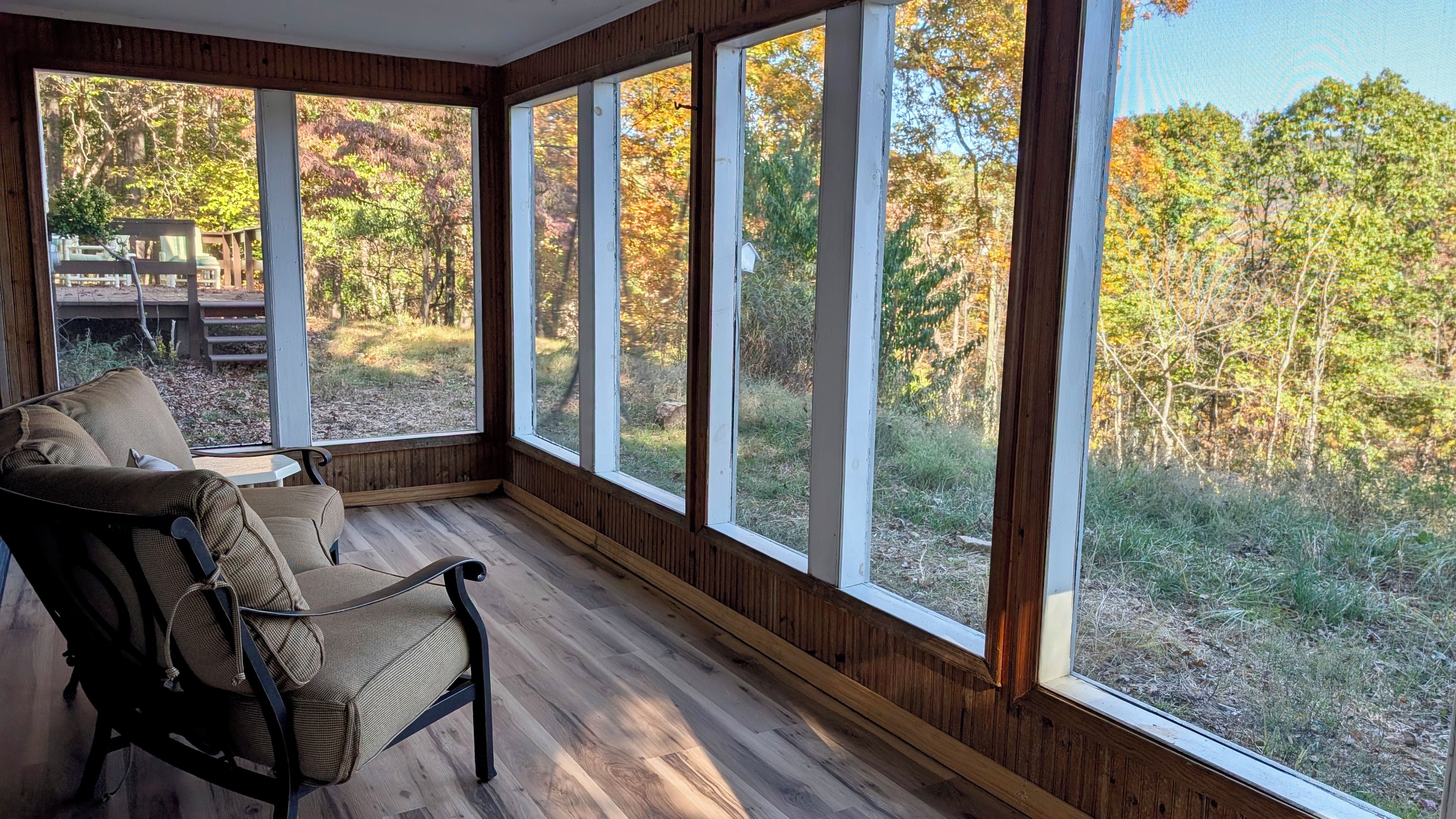 A room with a large window overlooking a wooded area.