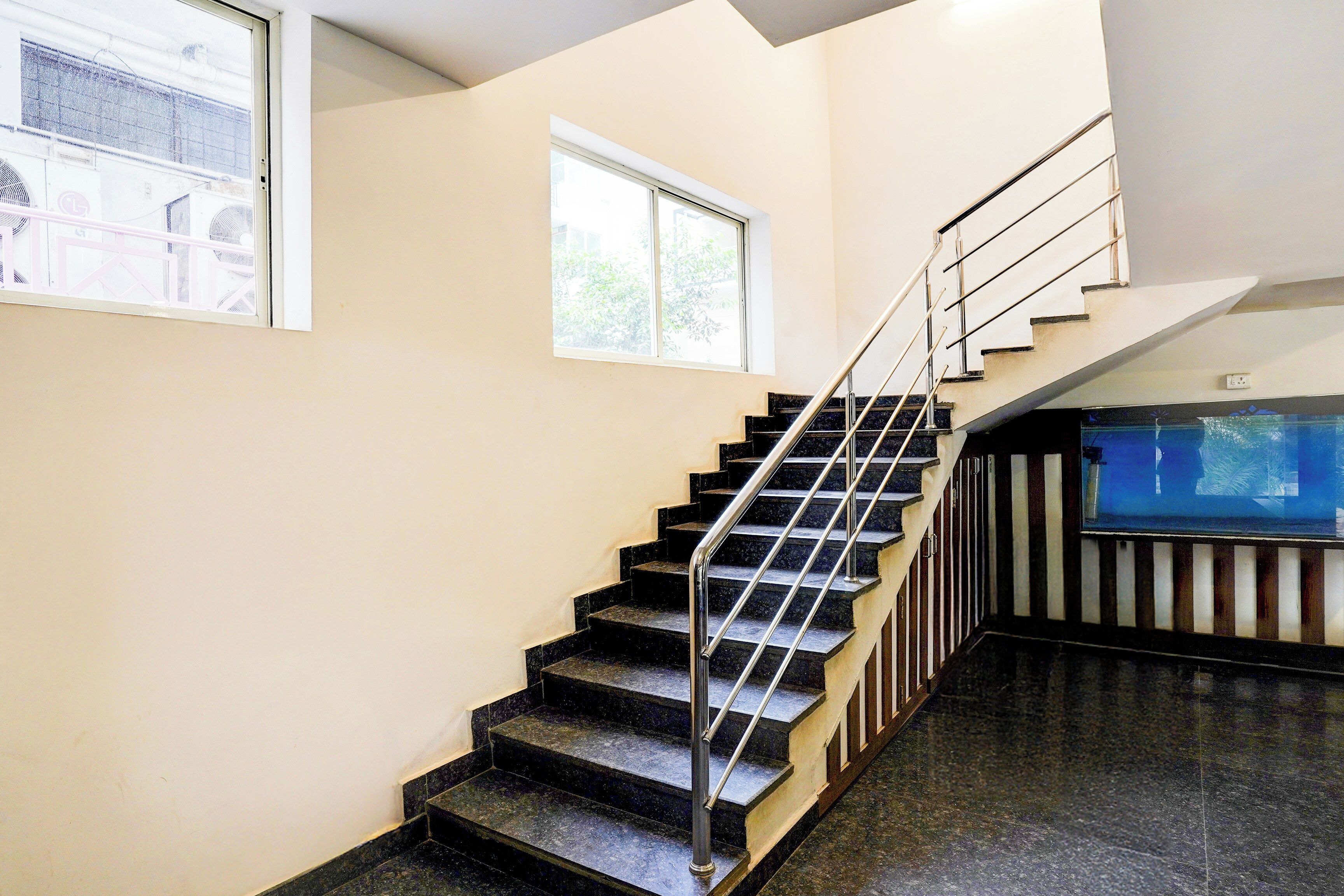 Una escalera con barandilla metálica que lleva a una plataforma con ventana.