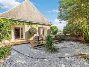 A house with a sloped roof, a patio with a chair, and a gravel area. - Le Laurier - Centre-ville - Petfriendly (Laval)