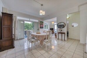 A dining area with a round table, chairs, and a cabinet. - Gasparin - Vue mer - Climatisation (Saint-Denis)