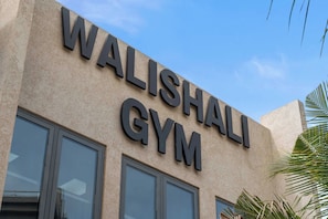 A building with the sign 'WALISHALI GYM' indicating a gym facility. - 2BR Luxury Escape | Pool, Palapa & Outdoor Shower (Noord)