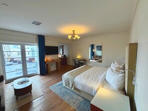 A hotel room with a bed, a desk, a chair, a TV, and a large window. - Ocean View Penthouse on Ocean Drive with a Private Pool Oasis (Miami Beach)