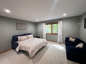 A bedroom with a bed, a sofa, a window with curtains, and a wall-mounted light fixture. - Welcome to the "Cozy Hideout" Charming 3/3 home in the Lake Ariel community. (Lake Ariel)
