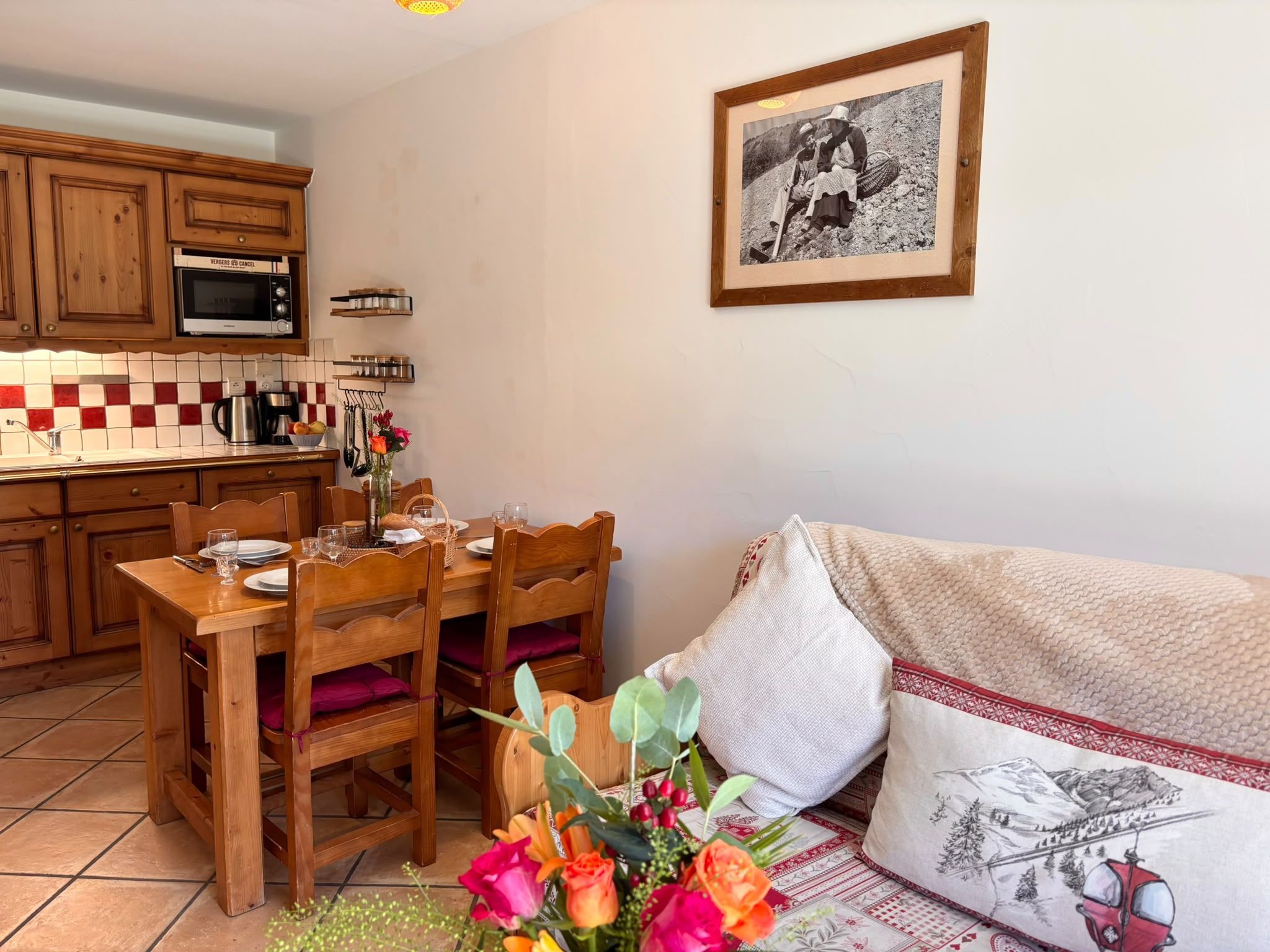 A cozy kitchen with wooden cabinets, a microwave, and a tiled backsplash.