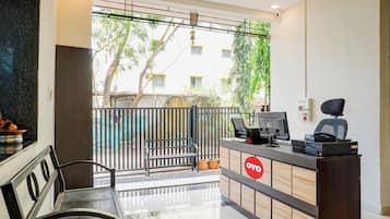 Una zona de recepción con mostrador, banca y vista al exterior.