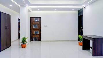 Una habitación de hotel moderna con un armario grande, una puerta de madera y dos plantas en macetas.