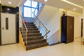 Una escalera con barandillas de metal y escalones de granito que conducen a una plataforma.