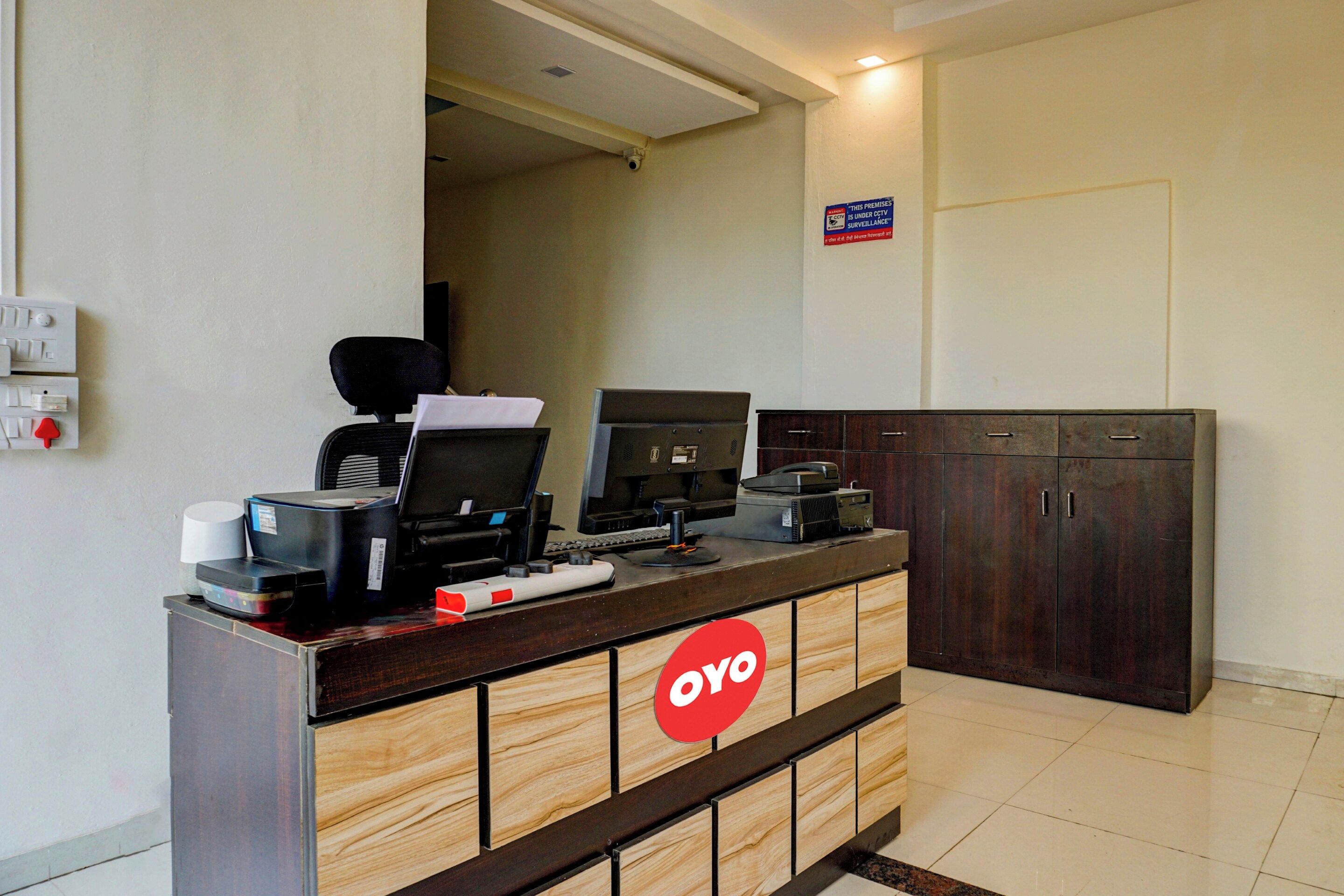 Una mesa de recepción con un logotipo, una computadora, una impresora y un teléfono.