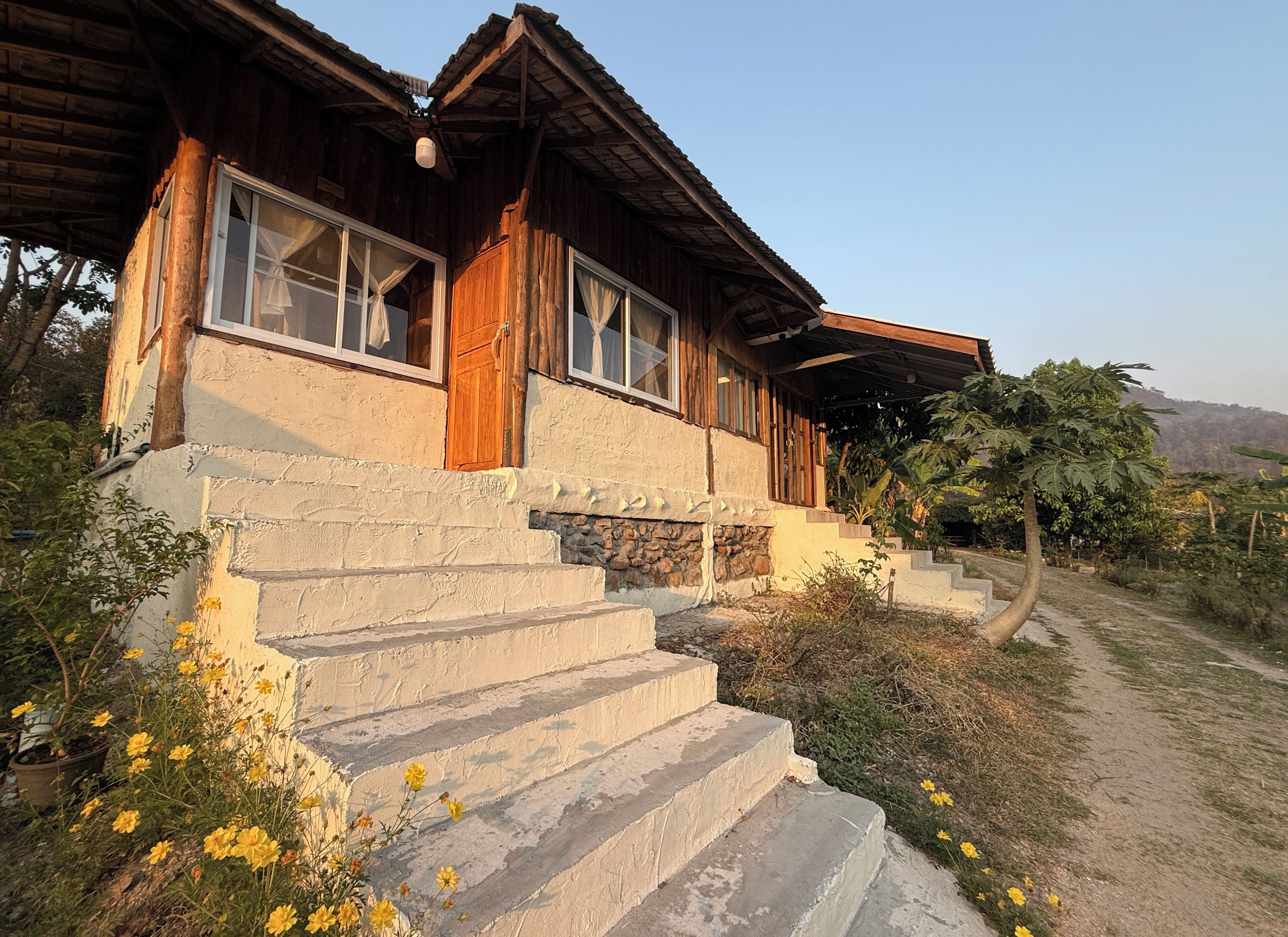 Una casa rústica de madera con una escalera de piedra que lleva a la entrada.