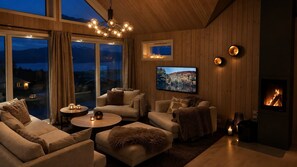 A cozy living room with a fireplace, comfortable seating, and a television. - Unique Lofoten Cabin with Spectacular Ocean Views and Sauna (Nordland)