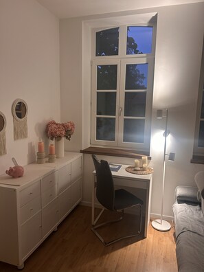 A small, well-lit room with a desk, chair, and a window with a view. - Cozy 2-room apartment for a relaxing getaway (Müden (Aller))