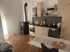 A compact kitchen with a built-in oven, a coffee machine, and a small dining table with a placemat. - Cozy 2-room apartment for a relaxing getaway (Müden (Aller))