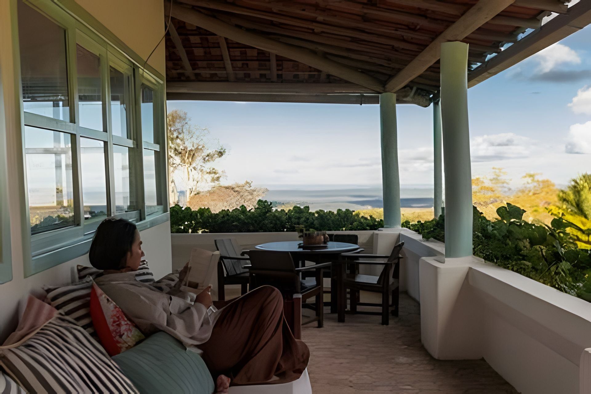 Uma área de estar coberta ao ar livre com vista para o mar.