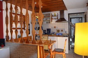 A kitchen with wooden furniture, a dining table, and a yellow lamp. - Vacation Home Am Stein – Family Comfort in the Elbe Sandstone Mountains (Königstein)