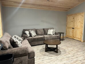 A living room with a sofa set, a coffee table, and a wooden cabinet. - Arkansas Cabin

Wonderful 3-bedroom triplex in charming Kirby next to the lake. (Kirby)