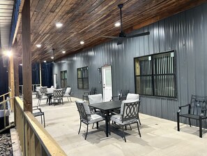 An outdoor patio area with a wooden ceiling, metal walls, and a table with chairs. - Arkansas Cabin

Wonderful 3-bedroom triplex in charming Kirby next to the lake. (Kirby)