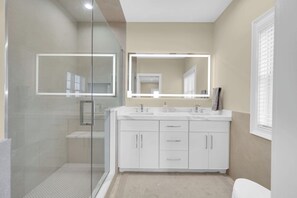 A modern bathroom with a glass-enclosed shower, a double vanity with a large mirror, and a toilet. - Lavallette Beach House 4BR/3BA - Perfect for Fall Getaways! - Sleeps 10 - Unit A (Lavallette)
