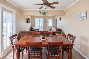 A dining room with a wooden table and chairs, a ceiling fan, and a 'Friends & Family' sign on the wall. - Rest Easy in Dildo | By the Sea | South Dildo (South Dildo)