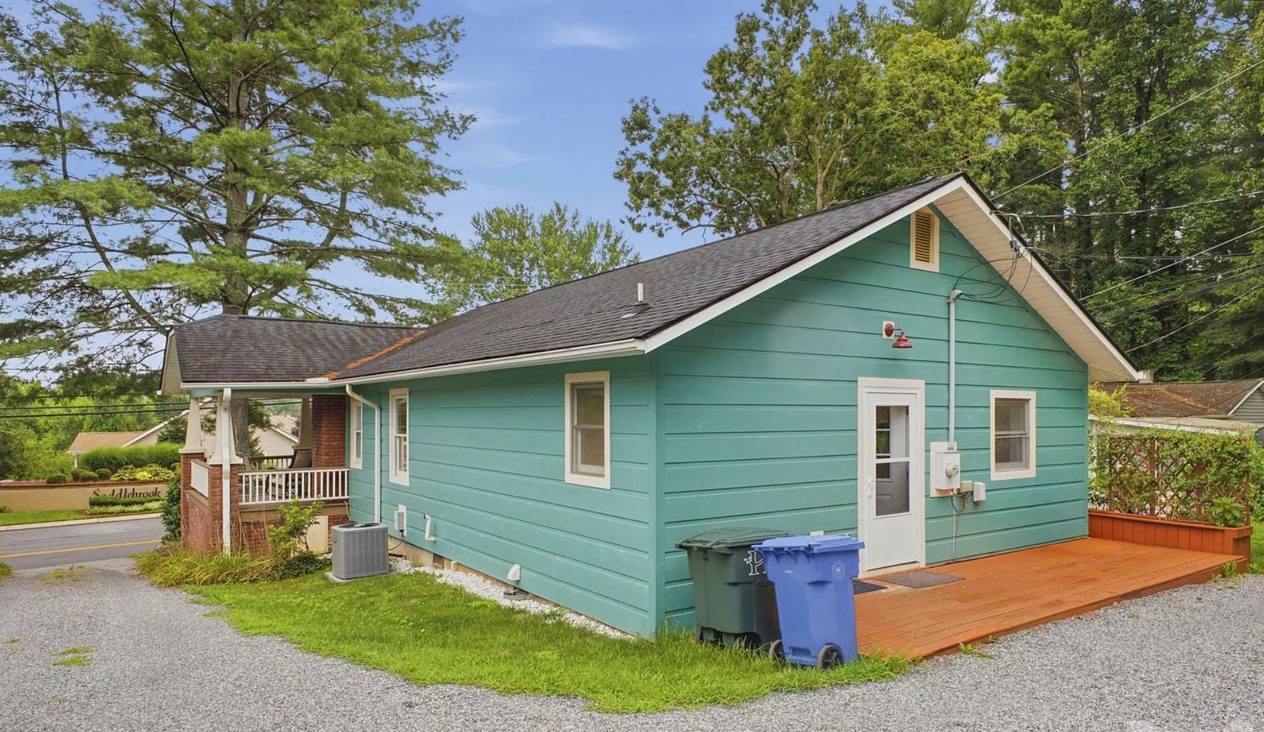 A small, single-story house with a porch, a front door, and a small front yard.