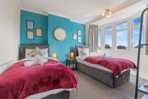 A hotel room with two beds, teal walls, and a large window. - 3BR 3Bath Solihull | JLR • NEC • Airport • Parking (Solihull)