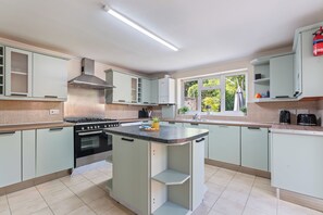 A modern kitchen with a central island, stainless steel appliances, and a view to the outdoors. - 3BR 3Bath Solihull | JLR • NEC • Airport • Parking (Solihull)