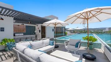 A rooftop pool area with outdoor seating and a bar.