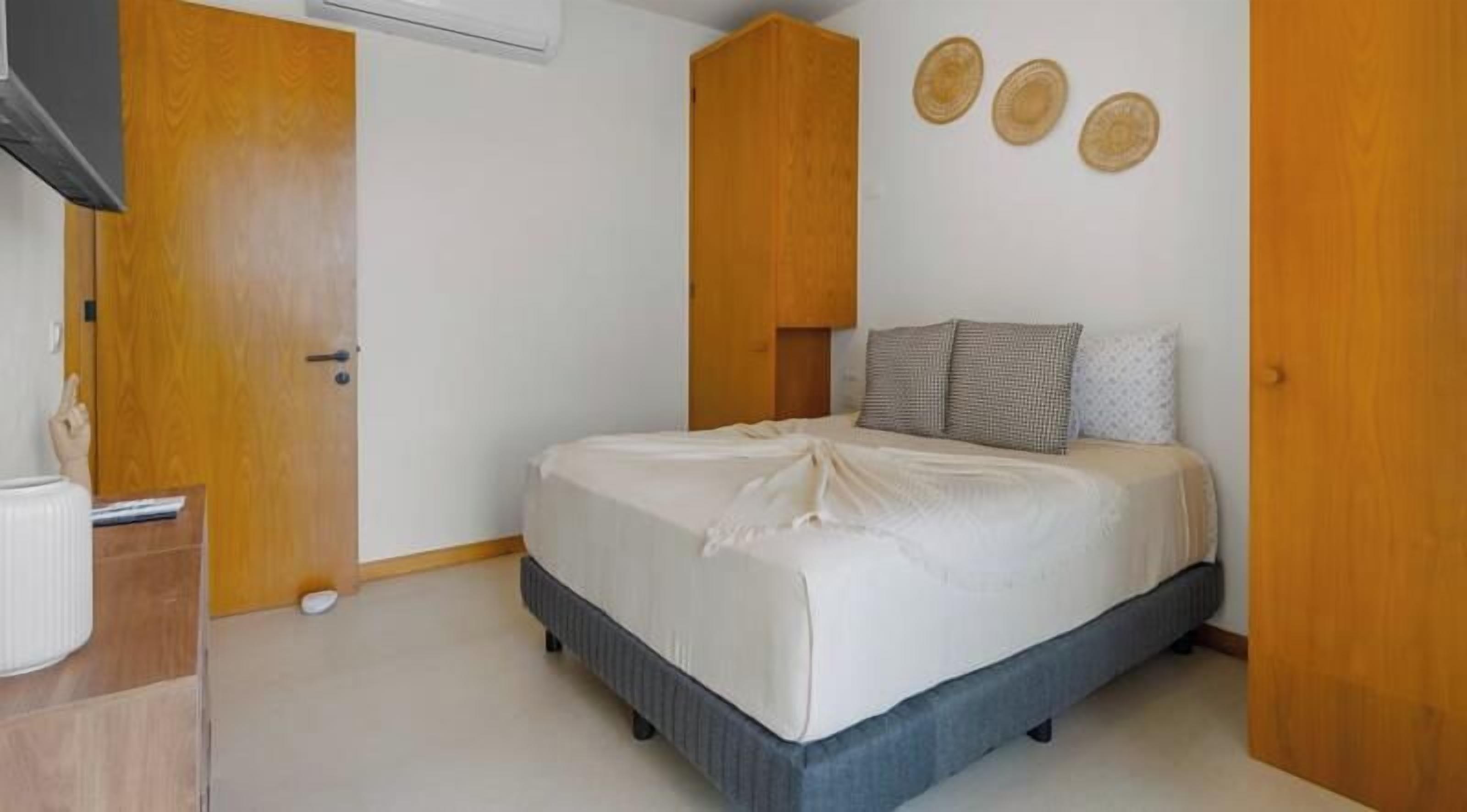 Ein Schlafzimmer mit einem Bett, einem Holzschrank und einem Nachttisch.
