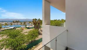 A balcony with a view of a marina and palm trees. - New Listing 2BR Condo Near the Ocean With Pool, Gym, Wifi, and Parking (La Cruz de Huanacaxtle)