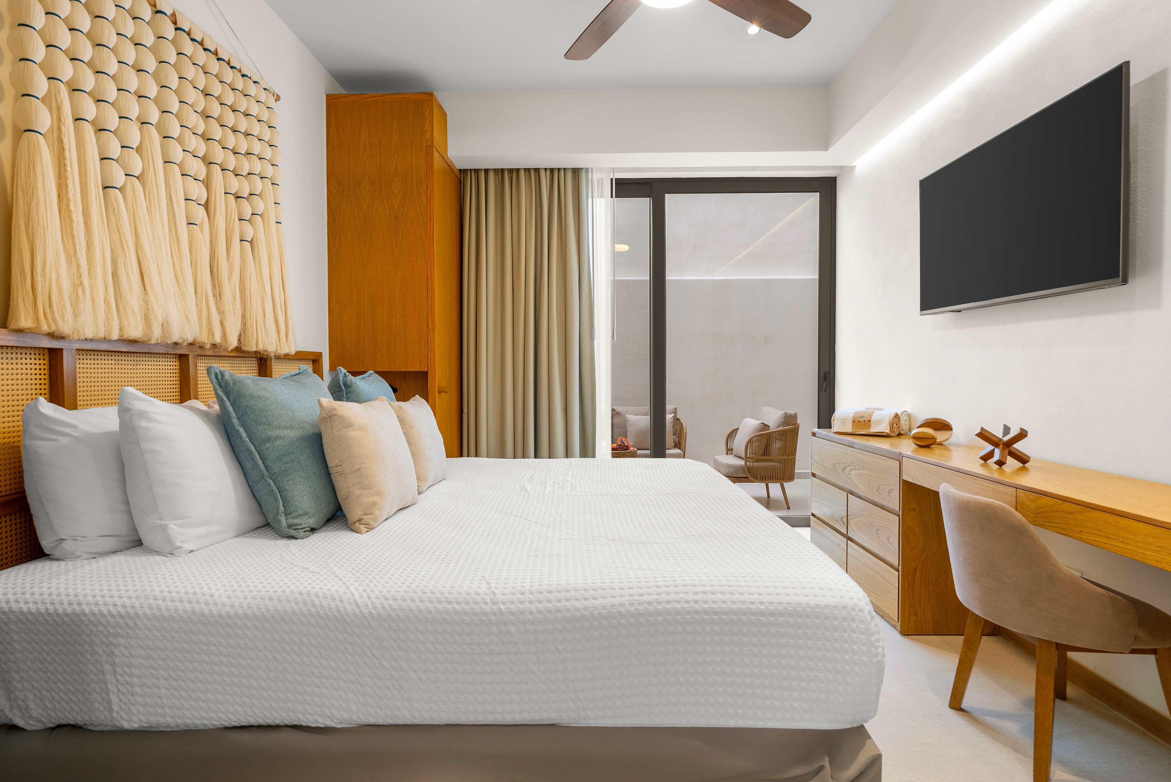 Een moderne hotelkamer met een groot bed, een bureau en een televisie.