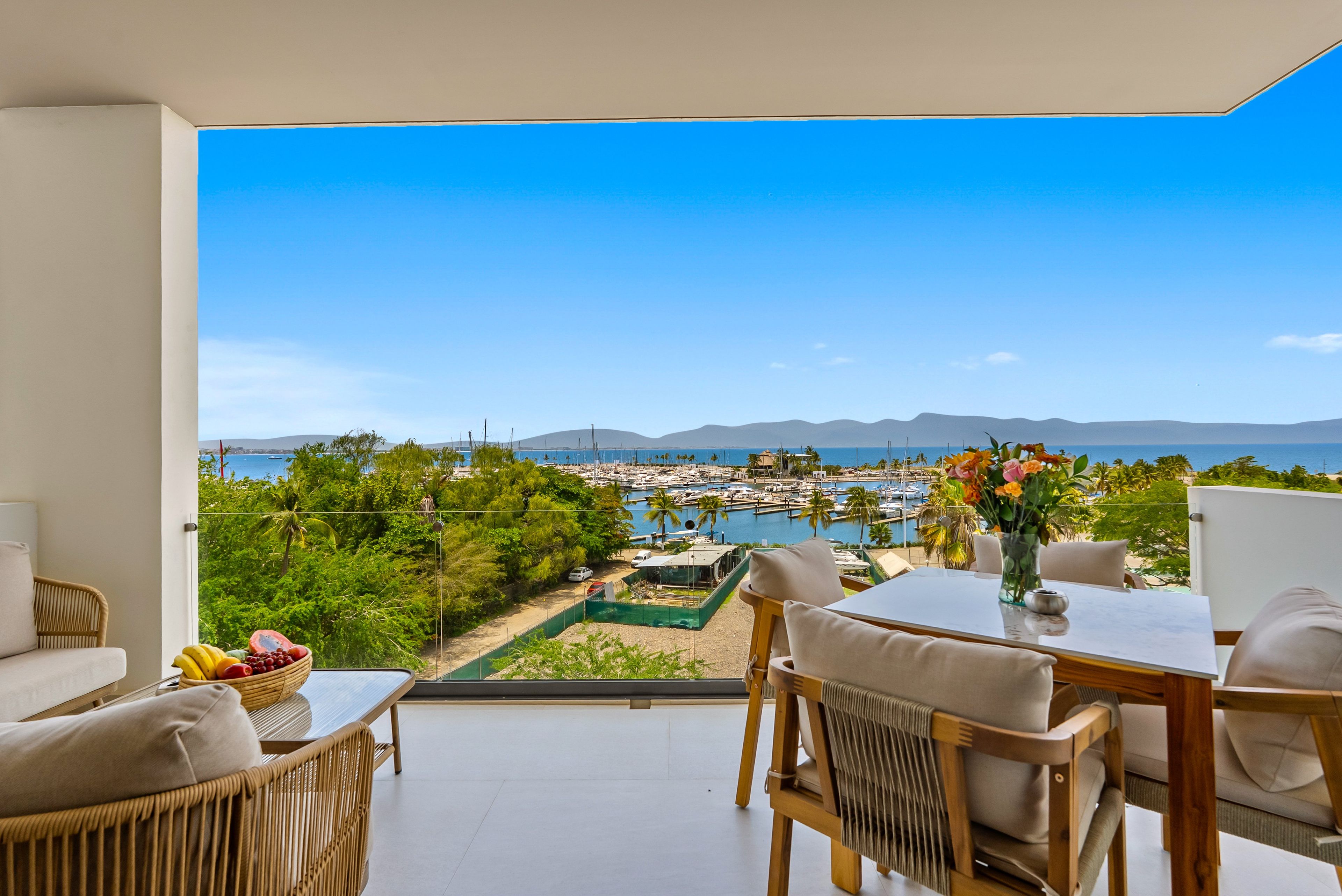 A balcony with a view of a marina and mountains.