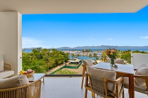 A balcony with a view of a marina and mountains. - 2BR Condo Near the Ocean With Pool, Gym, Wifi, Balcony (La Cruz de Huanacaxtle)