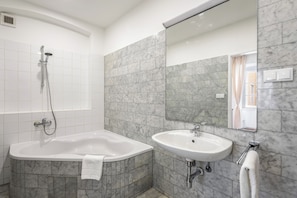 Une salle de bain avec une baignoire, un lavabo et une douche.
