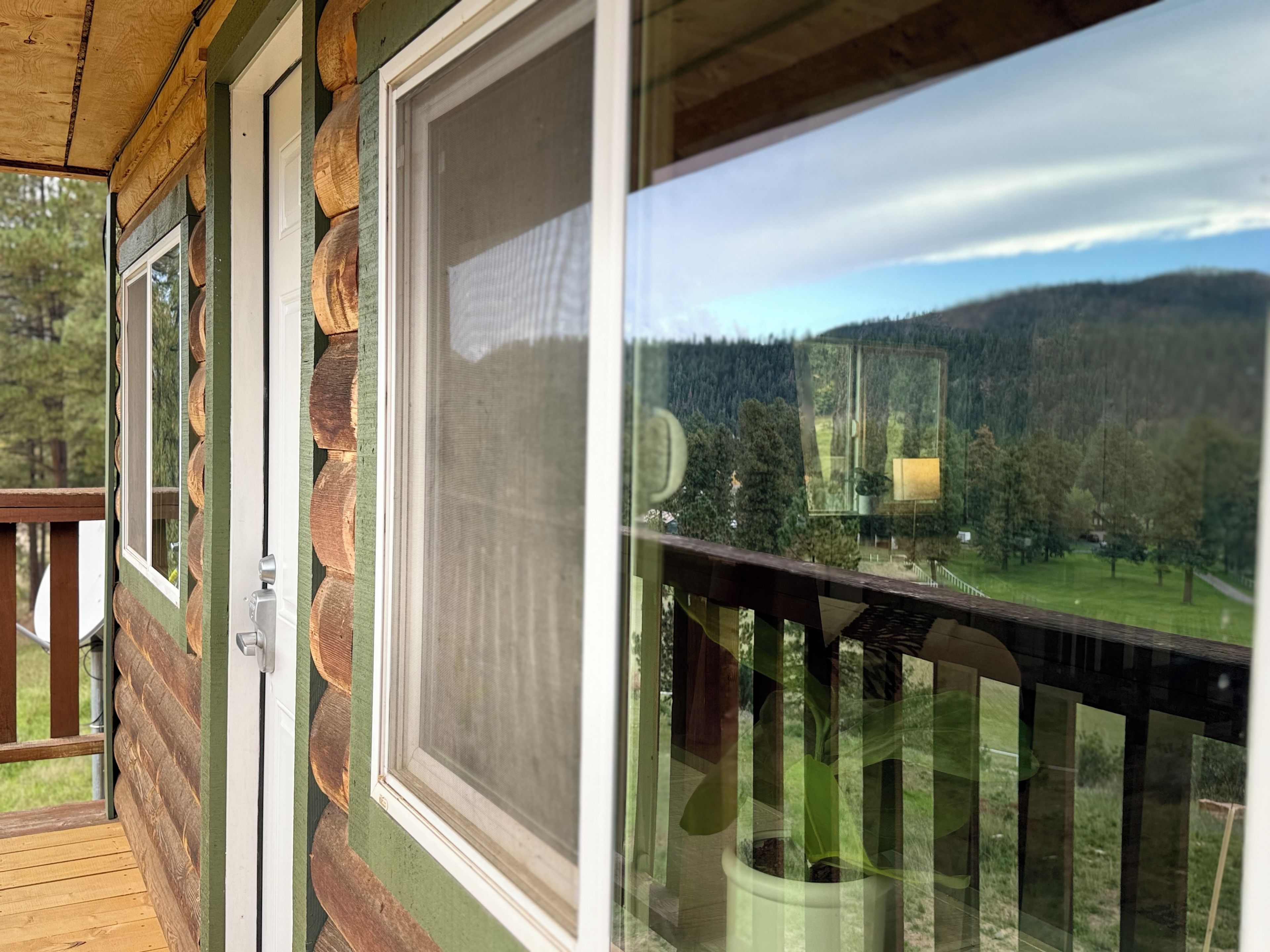 A wooden deck with a view of a forested mountain range.