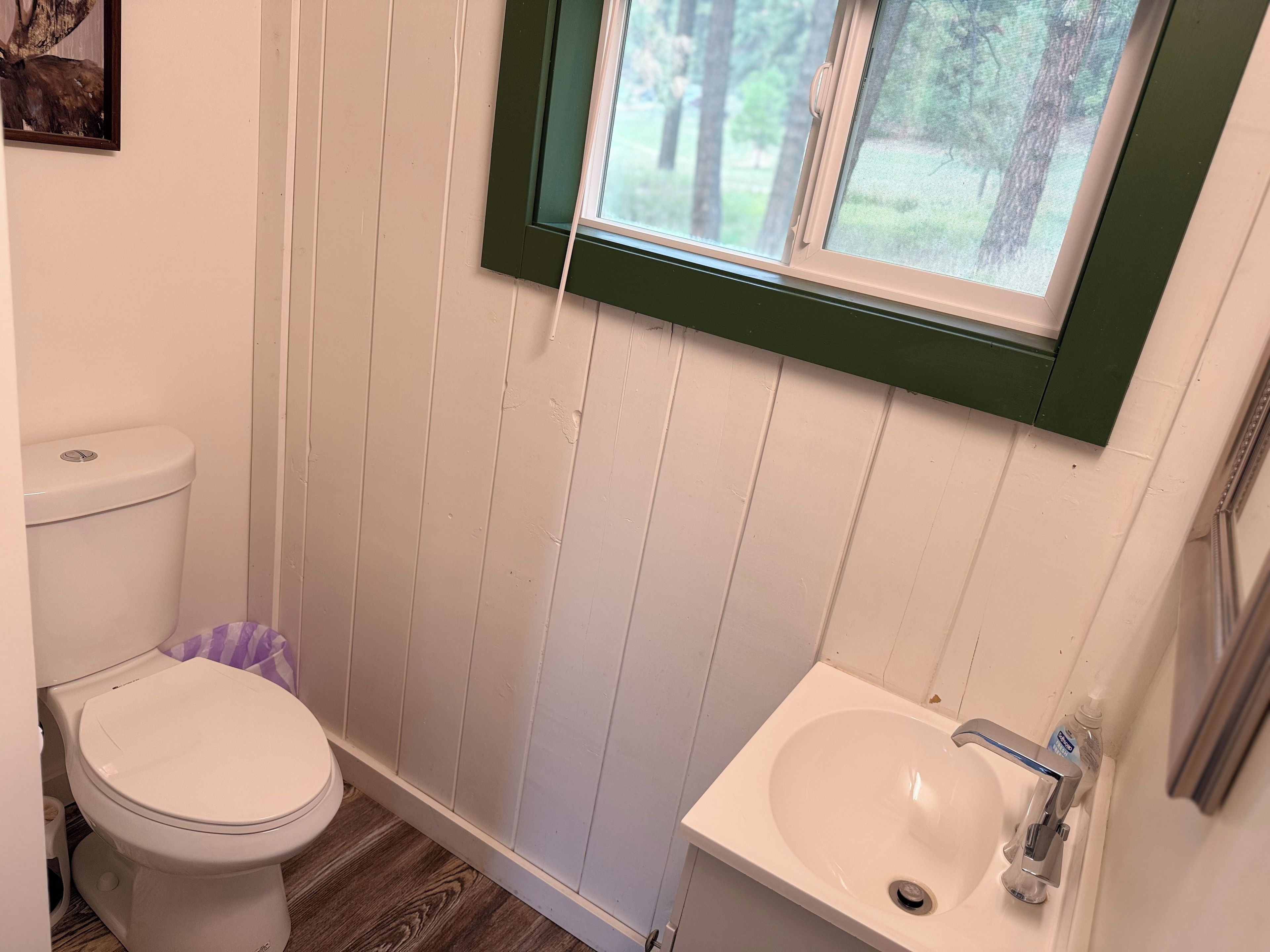 Un baño pequeño con inodoro, lavamanos y ventana.