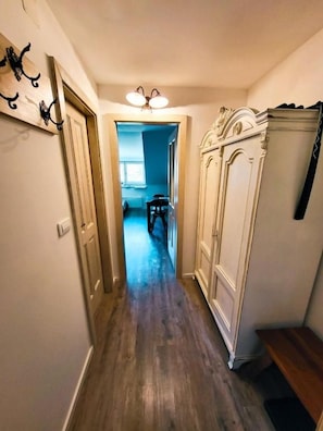A hallway with a wooden floor, a white cabinet, and a door leading to another room. - Two Bedroom Soul with Free Parking (Kranjska Gora)