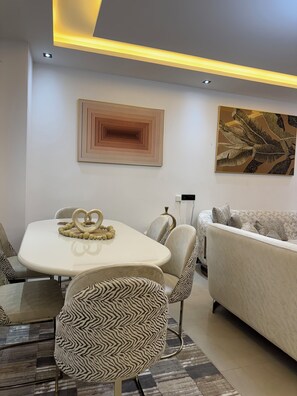 A modern living room with a dining table, sofa, and decorative art pieces. - Warn and Cozy 2-bedroom apartment in perfect Dakar-Almadies (Dakar)