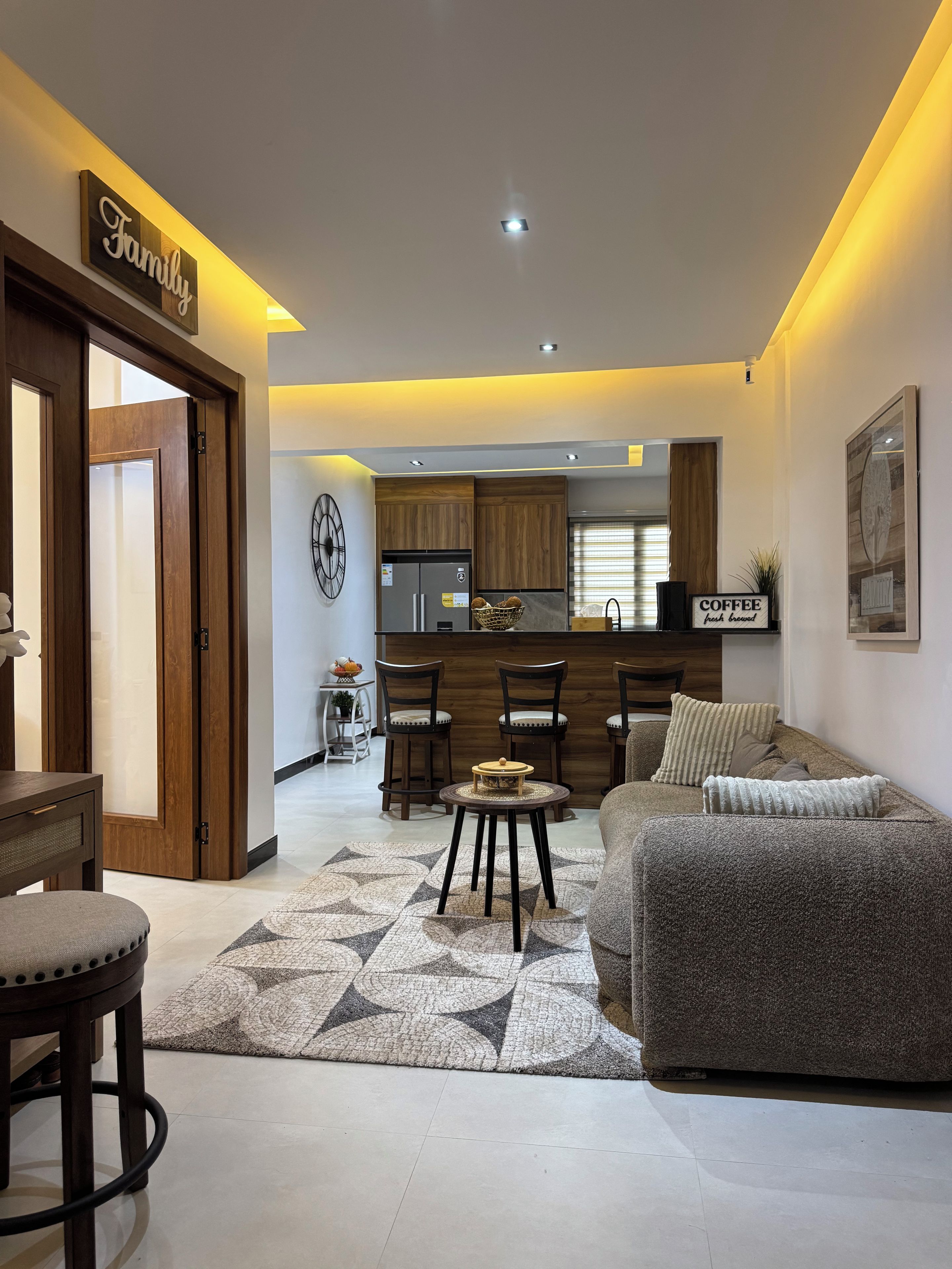 A modern living room with a sofa, a coffee table, and a dining area with chairs.