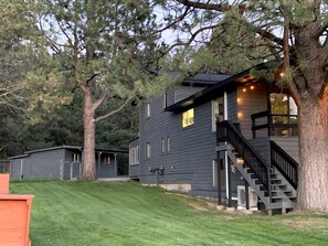 A two-story house with a staircase leading to the upper floor, surrounded by trees and a well-maintained lawn. - Spacious Lake House 5-bedrooms with Game Room in Cascade, ID (Cascade)