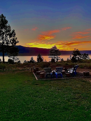 Un'ambientazione sul lago con posti a sedere all'aperto e vista sul tramonto.