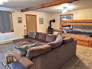 A cozy room with a sofa, a bunk bed, a small table, and a fireplace. - Spacious Lake House 5-bedrooms with Game Room in Cascade, ID (Cascade)