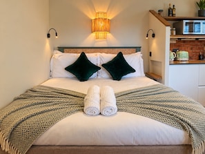 A neatly made bed with two pillows, a rolled towel, and a patterned blanket. - The Snug | Boutique Stay Clifton Village | Parking (Bristol)