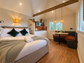 A bedroom with a bed, bedside lamps, a small kitchenette, and a seating area with a view of the outdoors. - The Snug | Boutique Stay Clifton Village | Parking (Bristol)