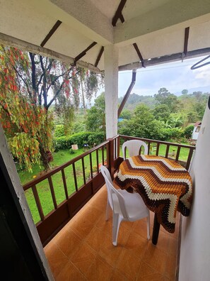A balcony with a view of a lush garden and distant hills. - La Quinta Esperanza | Country house with a pool, sauna, and natural surroundings (La María)