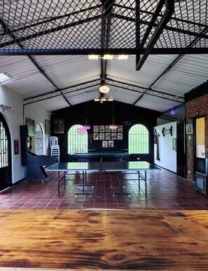 An indoor space with a ping pong table, a billiards table, and a brick wall. - La Quinta Esperanza | Country house with a pool, sauna, and natural surroundings (La María)