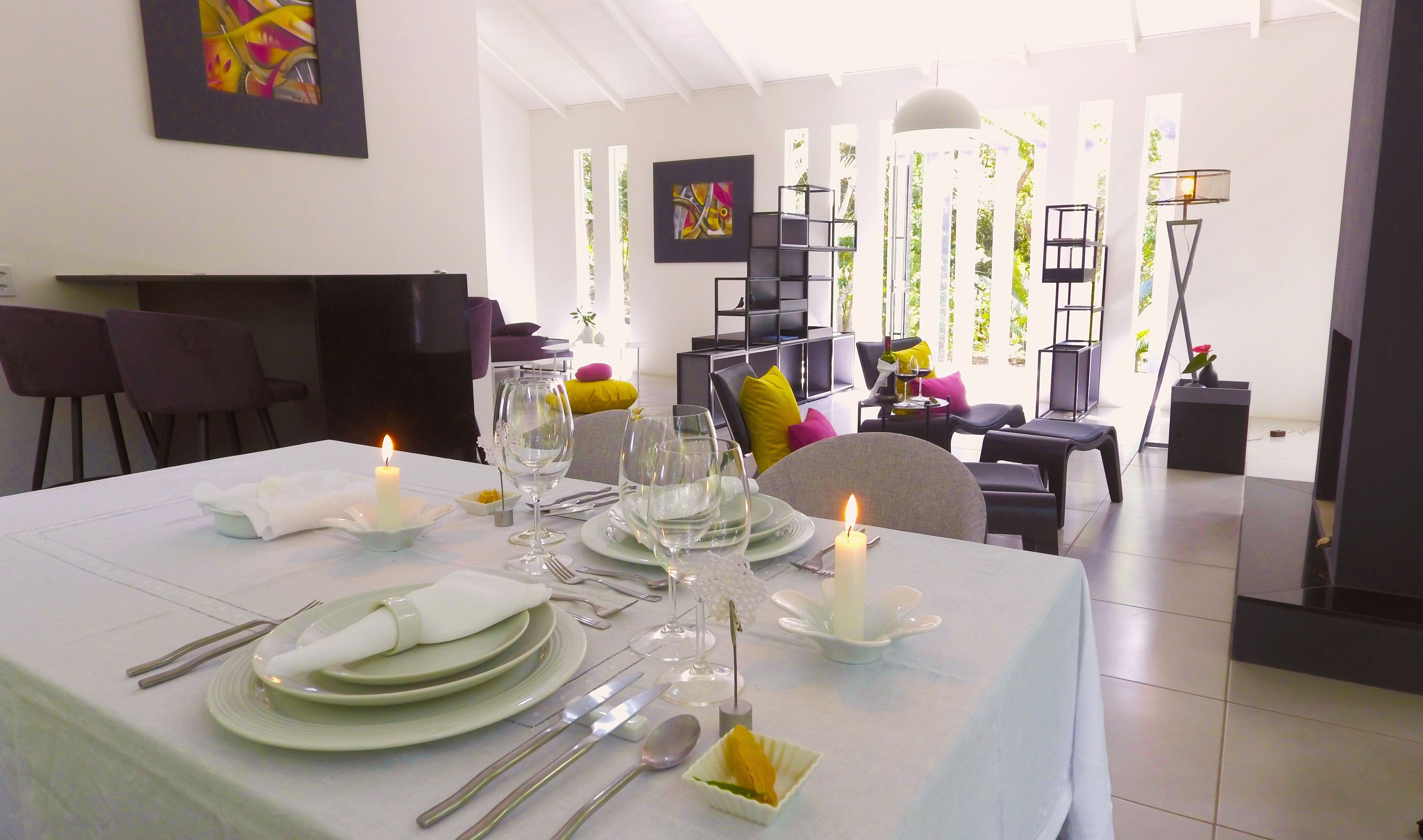 A dining area with a table set for a meal, featuring plates, cutlery, and glasses.