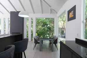 Una cocina moderna con comedor, ventanas amplias y vistas a zonas verdes.
