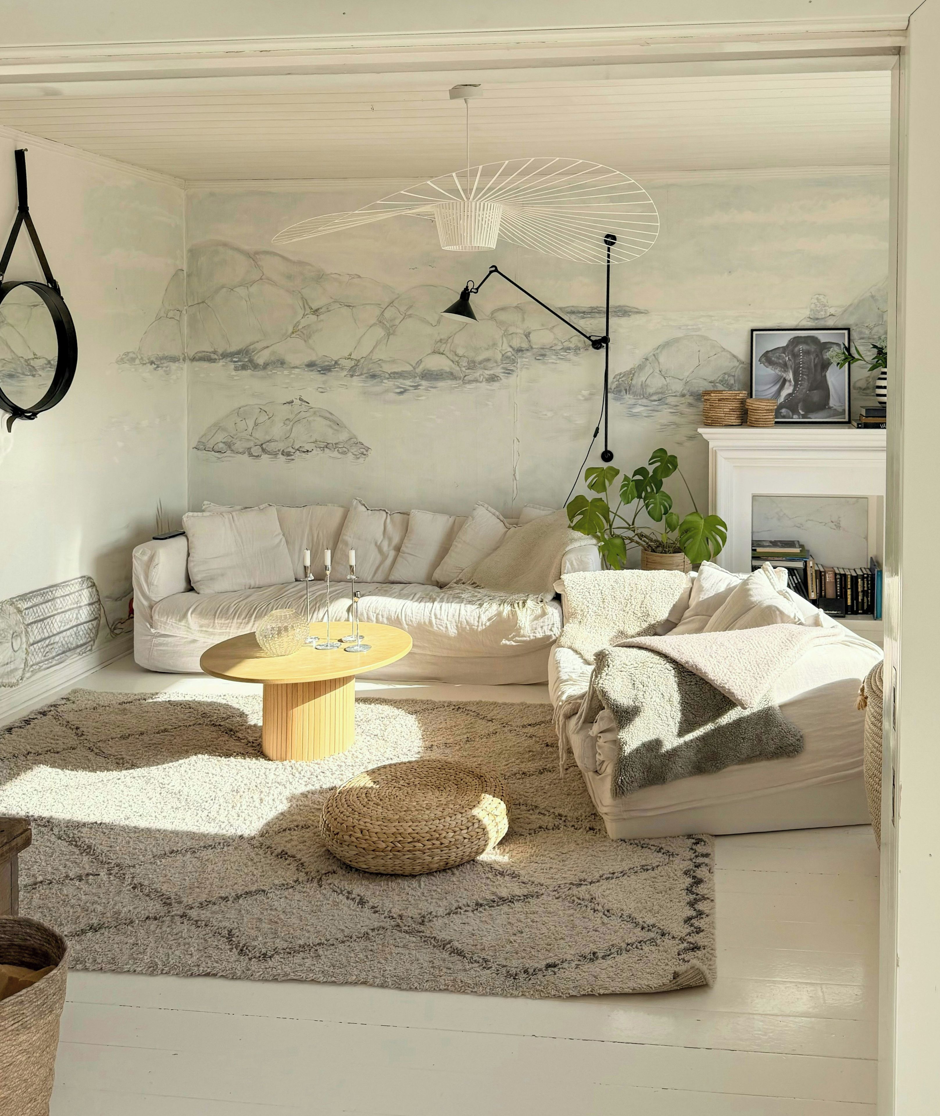 A living room with a sofa, a coffee table, a lamp, and a wall with a painting.