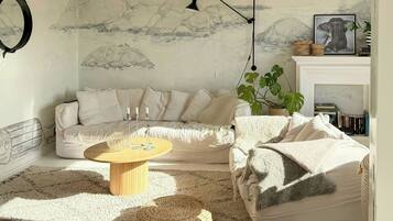 A living room with a sofa, a coffee table, a lamp, and a wall with a painting.