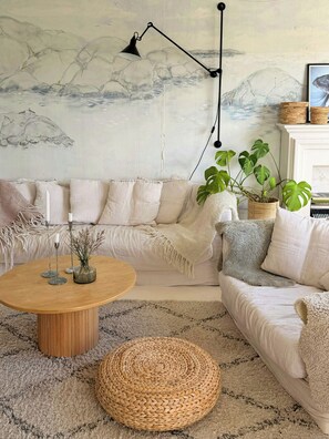 A living room with a sofa, a coffee table, a lamp, and a painting on the wall. - House with jacuzzi and sauna on Smögen (Smögen)